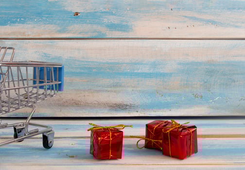 Shopping cart and Red gift box with sale concept on wood background. photo