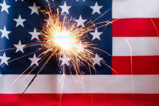 Concept for celebrating US Independence or Memorial Day. Sparkler on a background of American flag. photo