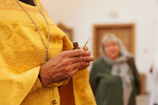 Orthodox Church. Christianity. Priest hands holding oil for anointing at baptismin on traditional Orthodox Church background. Religion faith pray symbol. Orthodox baptism celebration. photo