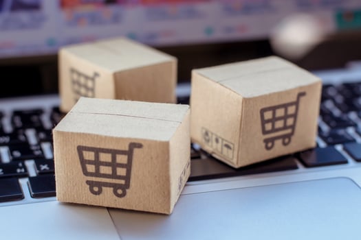 Shopping online. Cardboard box with a shopping cart logo on laptop keyboard. Shopping service on The online web. offers home delivery photo