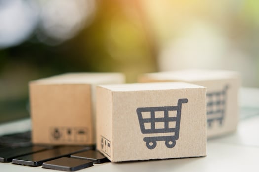 Shopping online. Cardboard box with a shopping cart logo on laptop keyboard. Shopping service on The online web. offers home delivery. copy space photo