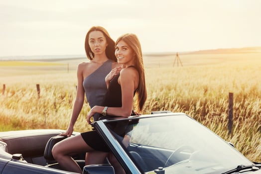 Girls posing for the camera in a black convertible photo