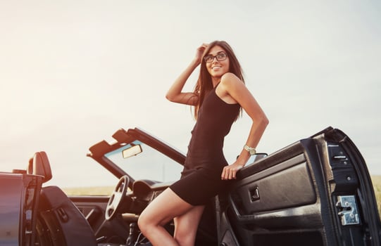 Girls gladly posing next to a black car photo
