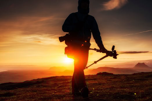 Happy man standing on a cliff at sunset photo