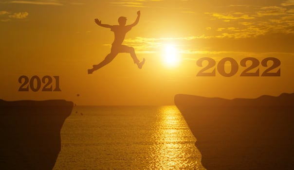 Silhouette man jump between 2021 and 2022 years with sunset background. photo