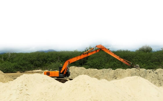 orange backhoe It is scooping up sand that blocks the river flowing into the sea so that ships can travel easily. photo