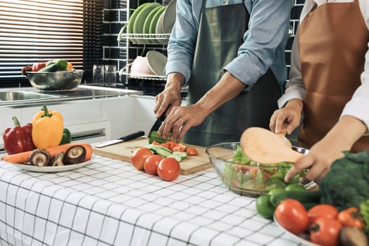 Two young asian couples are helping each other and enjoying cooking in the kitchen. photo