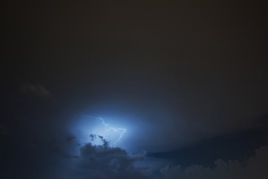 Lightning strike on the cloudy dark sky. Fantastic summer night photo