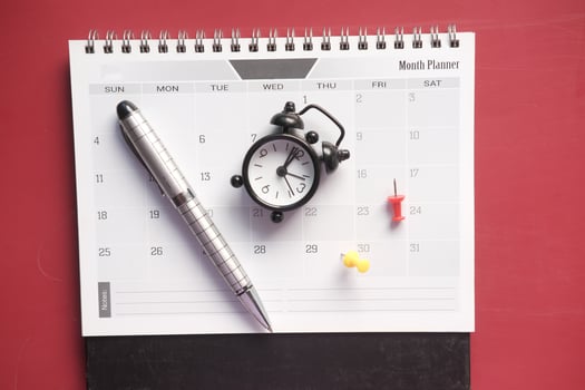 old alarm clock and calendar on red background. photo