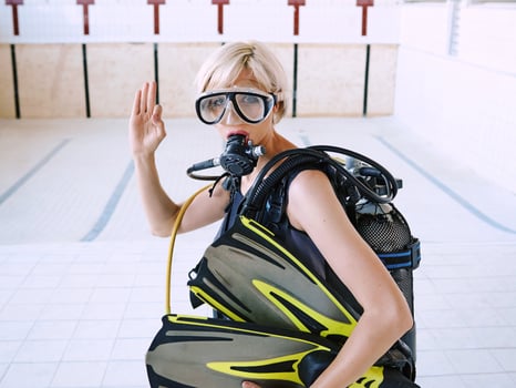 young blonde woman with diving equipment in empty swimming pool. Education, hobby concept photo