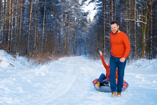 happy guy and girl riding in the snow photo