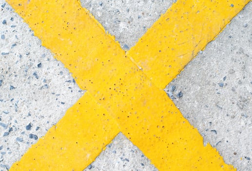 yellow cross symbol on the road photo