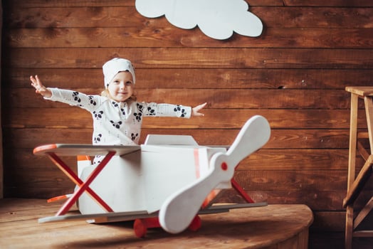 kid playing with wooden airplane photo