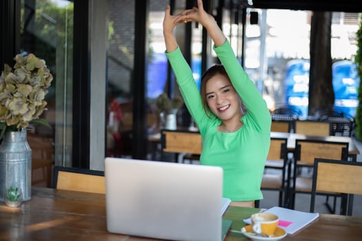 Asian woman stretching after reading book and work hard and smiling in coffee shop photo