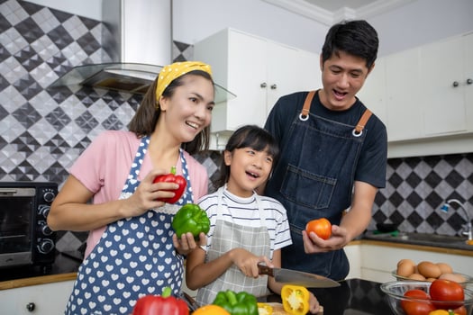 Happy Family have Dad, Mom and their little daughter Cooking Together in the Kitchen photo