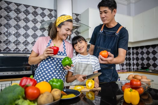 Happy Family have Dad, Mom and their little daughter Cooking Together in the Kitchen photo