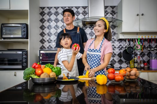 Happy Family have Dad, Mom and their little daughter Cooking Together in the Kitchen photo