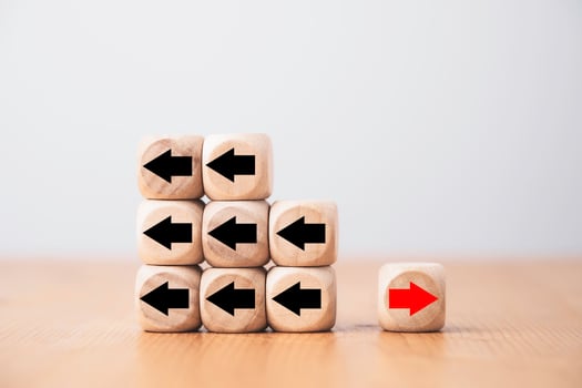 Red arrow on wooden move on different direction with black arrow on cube for business and technology disruption or unique concept. photo