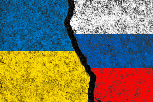 Russia flag and Ukraine flag print screen on wall crack for military conflict and attack concept. photo