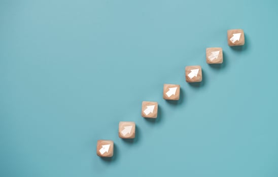 Business investment growth concept , Wooden cube block which print screen up and increase white arrow on blue background. photo