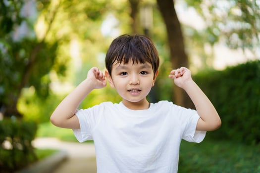 Happy Asian little boy enjoy playing and walking at the park with daddy close up, Asian boy have a beautiful smiling while looking at his father. Little boy portrait at the park and playground. photo