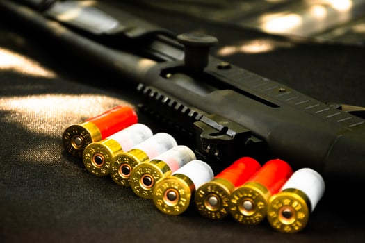 Shotgun, shotgun cartridges on a black leather background, soft and selective focus photo