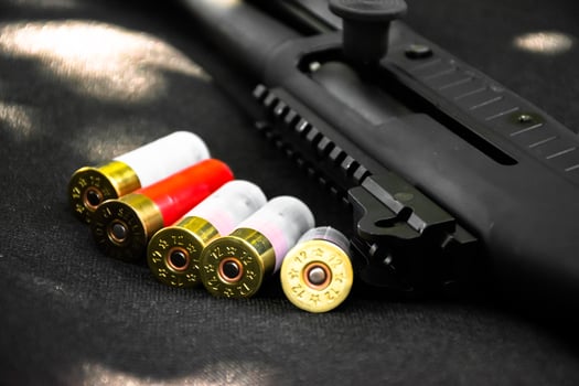 Shotgun, shotgun cartridges on a black leather background, soft and selective focus photo