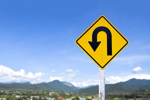 Left turn sign on white pole with clouds and blue sky background. photo