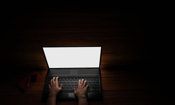 The hand of a person using a notebook or laptop, a blank screen, white, dark background, blacklight shines down on the hand. Mystery operation or hacker.3D Rendering photo