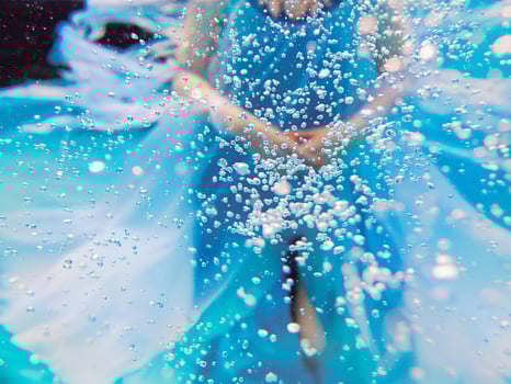 Abstract Underwater fashion portrait of beautiful young woman in blue dress thought air bubbles photo