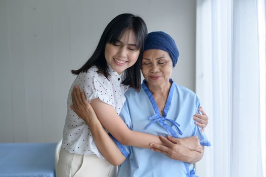 Cancer patient woman wearing head scarf and her supportive daughter in hospital, health and insurance concept. photo