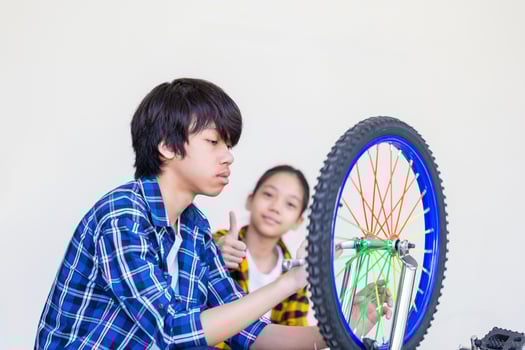 Brother and sister fixing bicycle together, Boy and girl repairing bicycle photo