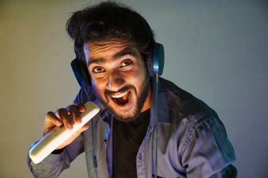 man try to immatate singing high note using his ac remote photo