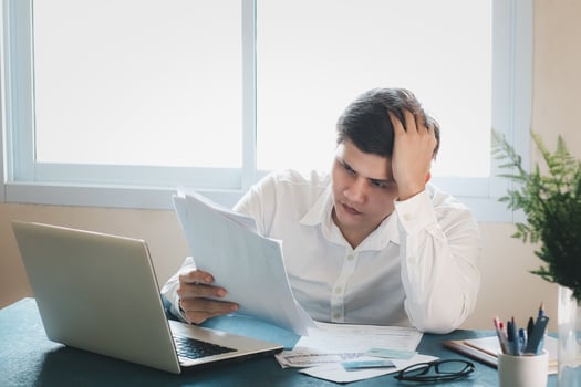 Young Asian men are stressed out in business office. Looking at expense bill and the other hand on head, thinking about finding money to pay credit card debt and all bills. Concept financial problems. photo