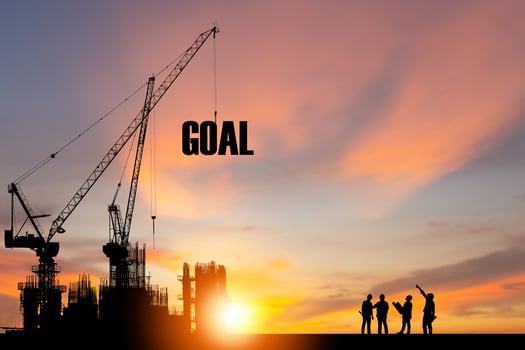 Silhouette of GOAL on construction site with crane and sunset sky for preparation business concepts photo