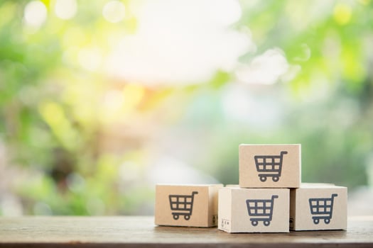 Online shopping - Paper cartons or parcel with a shopping cart logo and credit on wood table top with copy space. Shopping service on The online web and offers home delivery. photo