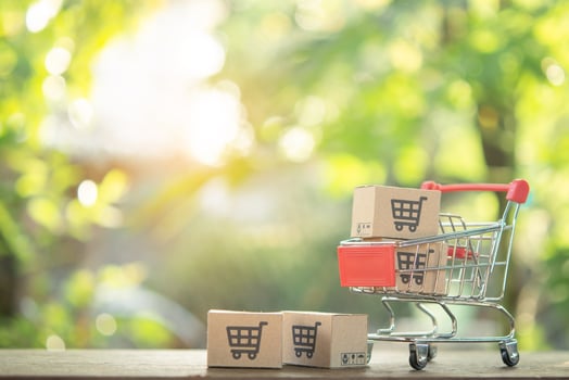 Shopping concept - Shopping cart or trolley and Paper cartons or parcel with a shopping cart logo on wood table. online shopping consumers can shop from home and delivery service. with copy space photo