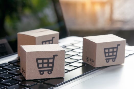 Online shopping - Paper cartons or parcel with a shopping cart logo on a laptop keyboard. Shopping service on The online web and offers home delivery. photo