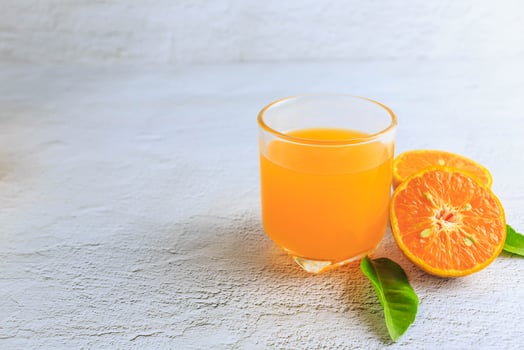 Freshly squeezed orange juice in a glass and fresh citrus fruits on a white background. photo