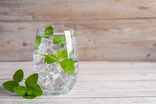 Mint leaf in cold fresh drink in glass on wood background. photo