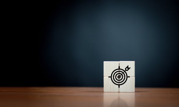 Focus on a goal and achieve successful business. Initiation for planning to reach target. Darts target aim icon on wooden cubes with dark  background. Copy space. photo
