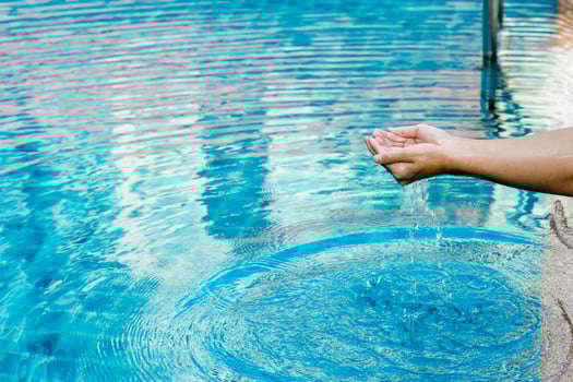 Hand and water touch the blue water. To refresh the concept of playing clean water with copy space. photo