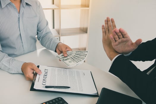 Businessperson refusing bribe given money by partner with anti bribery corruption concept. photo
