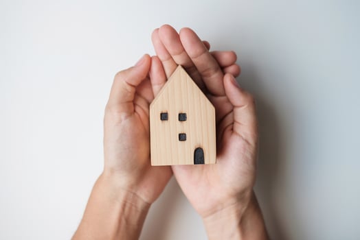 hand holding key with wooden Home model. Real estate, buy and sale, Property insurance, rental and contract agreement concepts photo