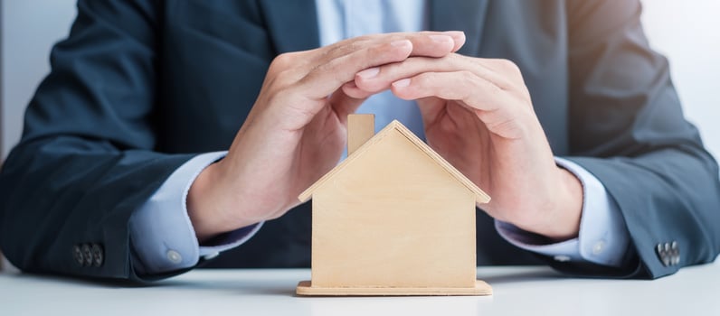 Businessman hand cover wooden Home model. real estate, insurance and property concepts photo