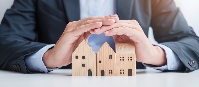 Businessman hand cover wooden Home model. real estate, insurance and property concepts photo