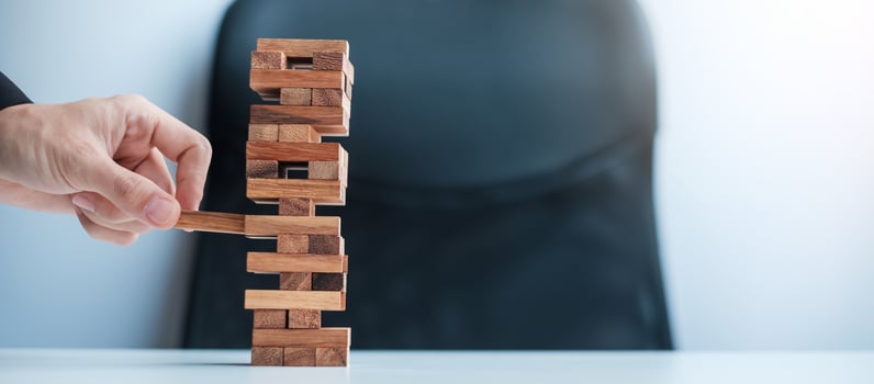 Businessman hand placing or pulling wooden block on the tower. Business planning, Risk Management, Solution and strategy Concepts photo
