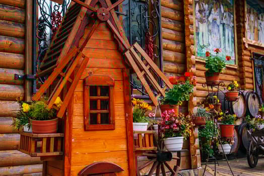 decorative mill and flowers near house photo