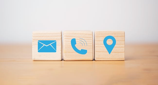 Blue  letter telephone location and address icons print screen on wooden cube block for customer service contact concept. photo