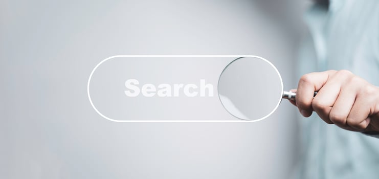 Hand holding magnifier glass with search bar icon for search engine optimisation or SEO concept. photo